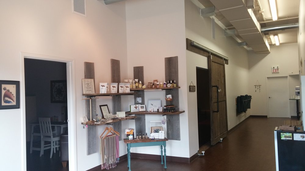 inside foyer of north yoga with product shelves in corner and hallway leading to studio