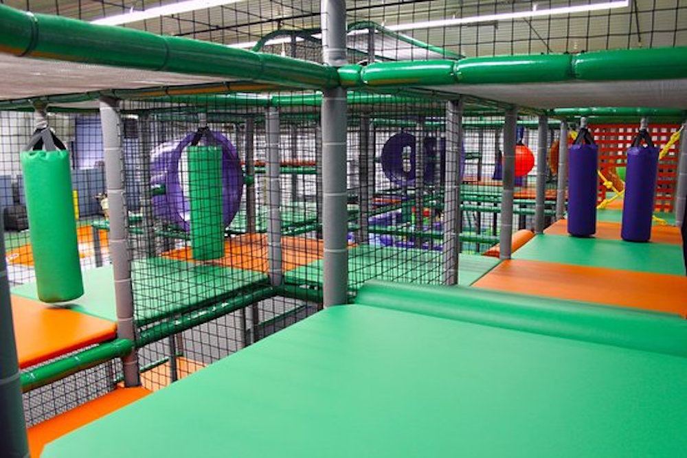 interior of kids play place with green matts and protective cages for crawling