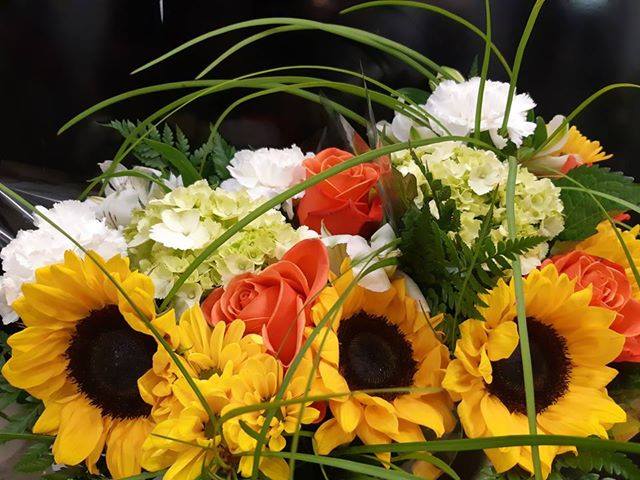 close up flower photo with sunflowers and other green accents