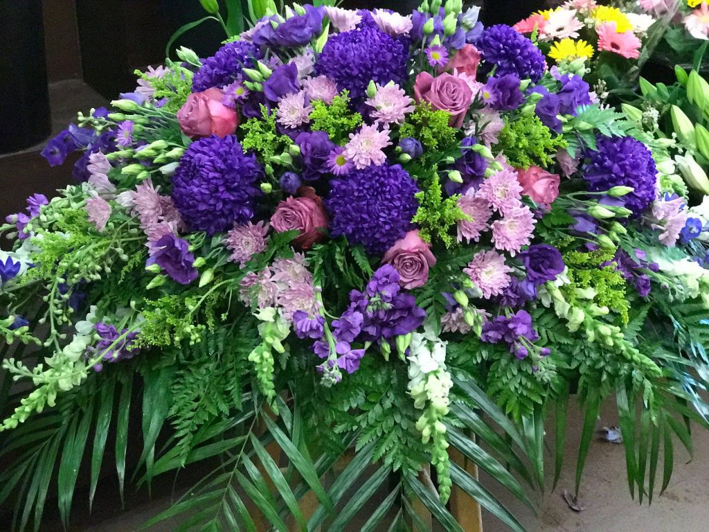 close up of mainly purple flower bouquet with green accents