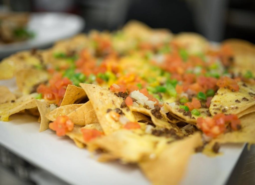 side view deluxe nacho on white plate