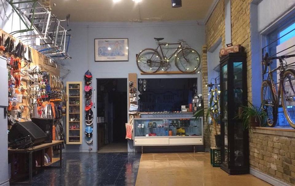 full view of bike workshop with bike hanging on back wall, and other accessories on the service counter