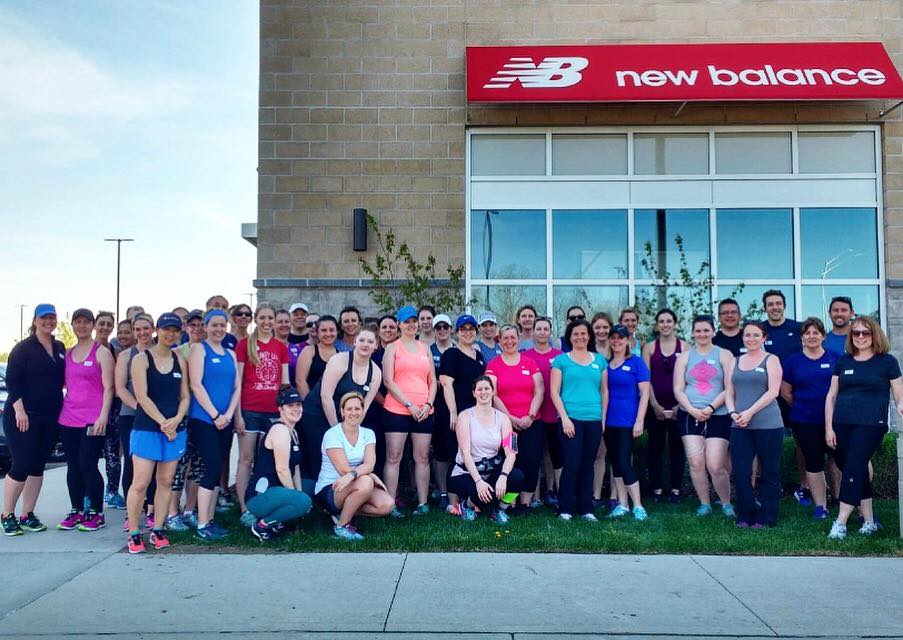 outdoor group shot of people in front of store wearing athletic wear after a workout or run
