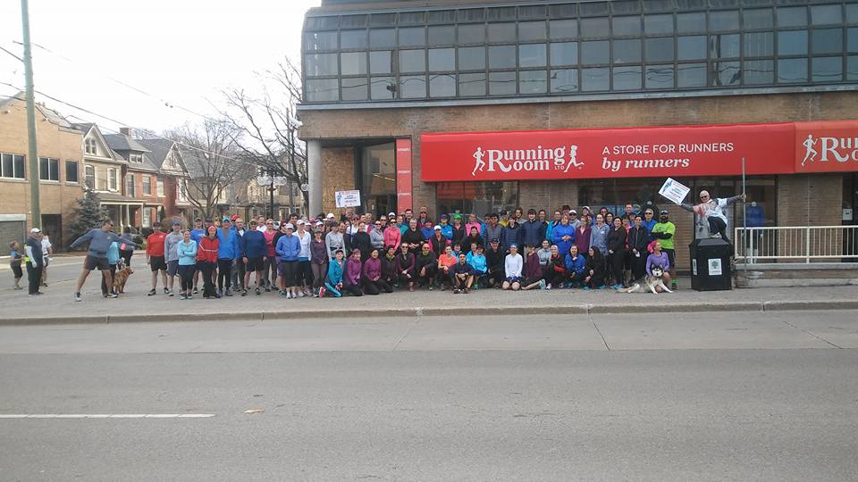 group shot of people in front of store front wearing athletic wear after a run or workout