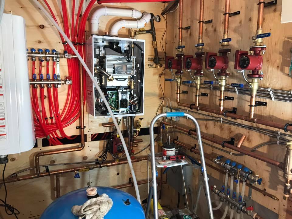 view of wiring and plumbing set up after completion against a wooden wall