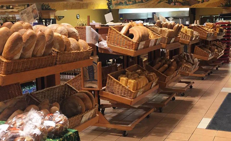 side view of multi layered shelving holding baskets of different kinds of bread