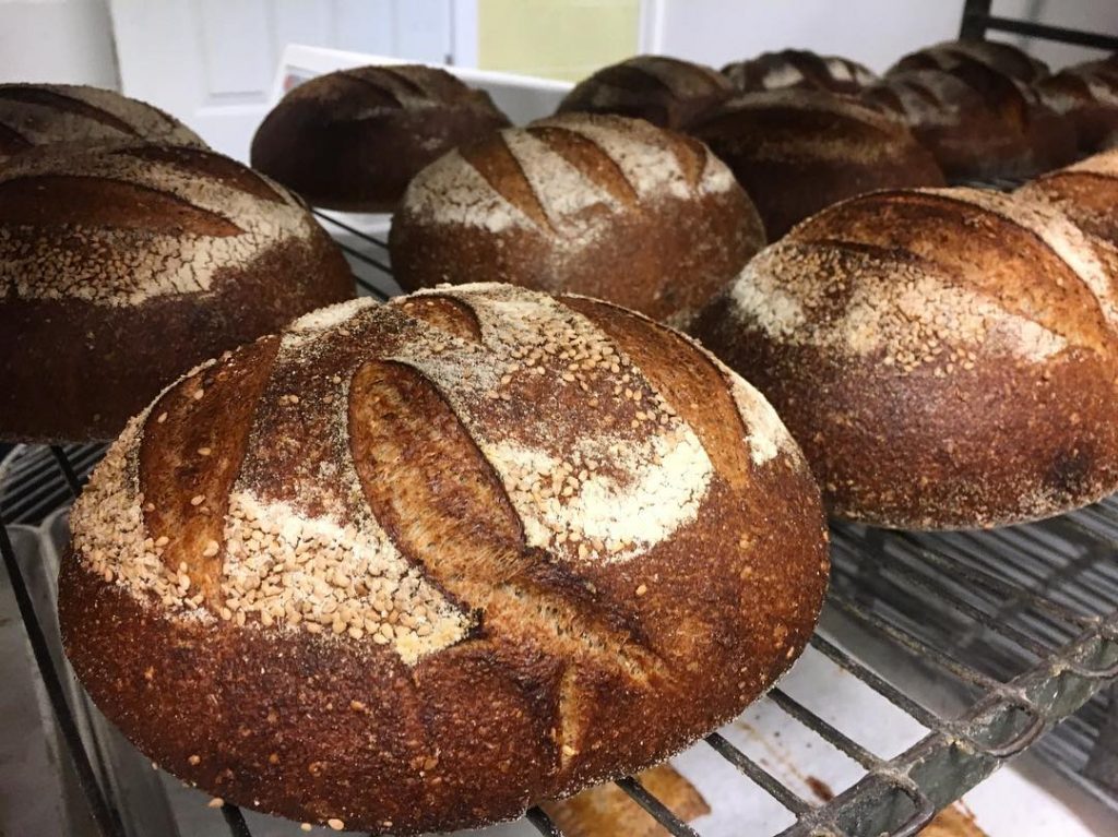 side view of loaves on oven racks with slits on top of loaves
