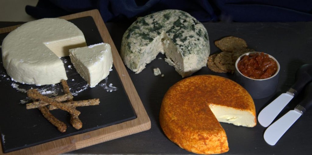 top view of three cheese wheels with pieces cut out and seperated