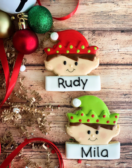 decorated elf cookies with names and ornament decor to the left