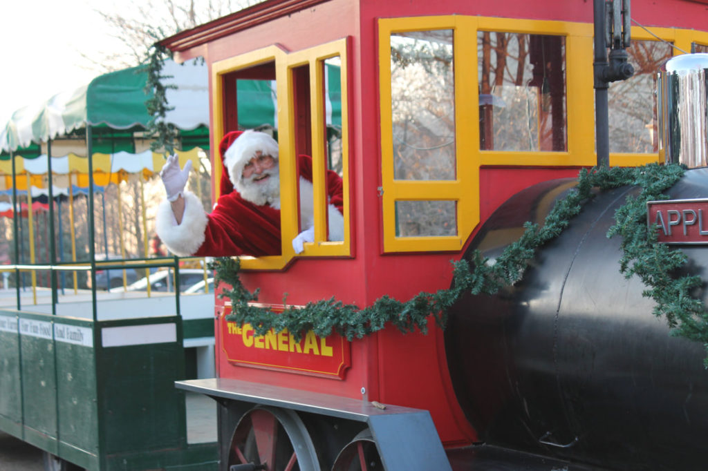 santa clause sticking his head out of a christmas train and waving