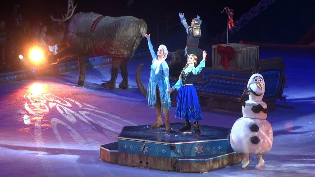 disney on ice frozen performers on platform waving towards crowd with snowman skating around