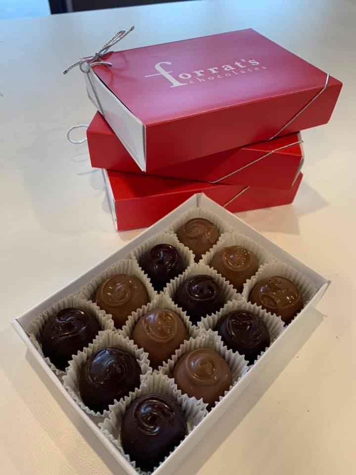 top view of box of chocolates in a red box with chocolates exposed sitting on a table