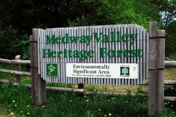 entrance to heritage trail sign made of wood with green lettering