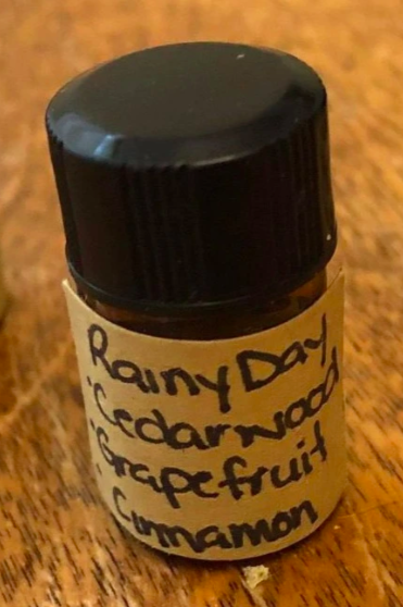 very small bottle of essential oil with handwritten label on the front and a black lid