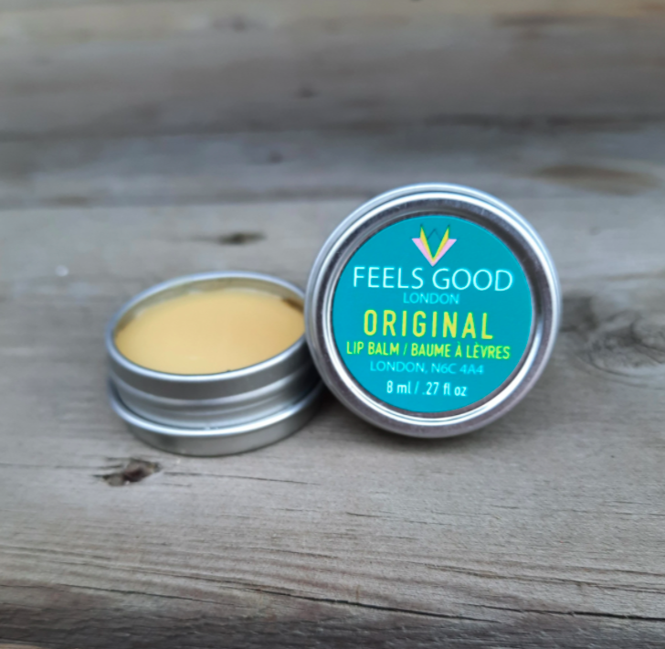 small twist bottle of lip balm with turquoise labelling sitting on a wooden bench