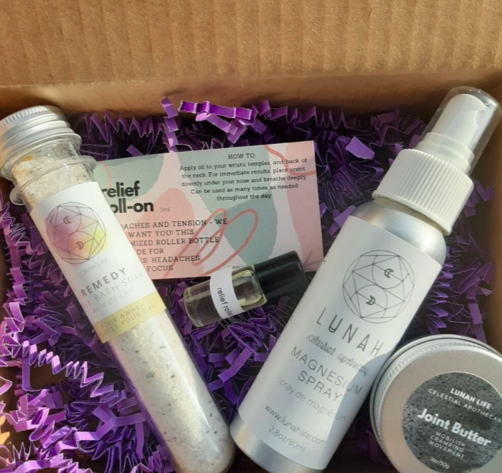 skincare bundle that has various shaped bottles and vials of things with different product labels sitting on purple pack wrap