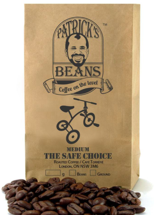 small brown bag of coffee beans with product branding and labelling on the front and coffee beans sitting in front of bag
