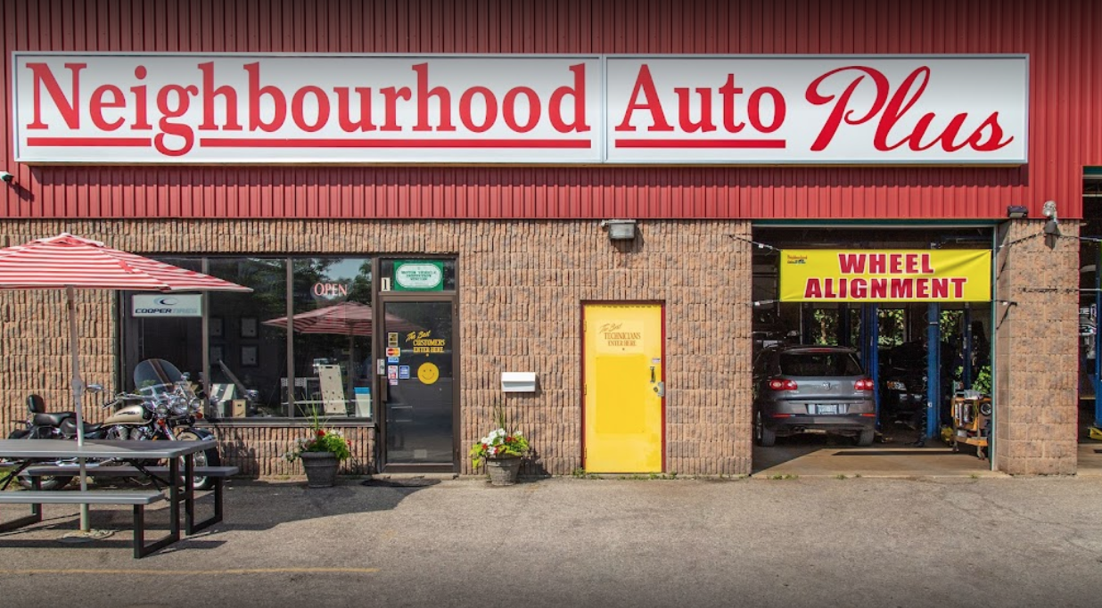 exterior of an auto mechanic with a picnic table to the left and garage door to the right with entrance in between