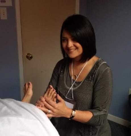 woman holding someone's foot performing a medical assessment smiling