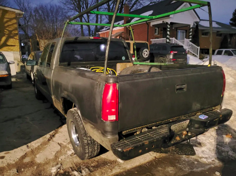 The back of a pickup truck parked in a driveway with a cab rack attached