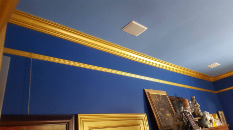 interior of a room with blue paint on the walls and gold crown moulding