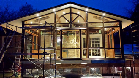 exterior of a house that recently had lights installed on inside and outside at dusk