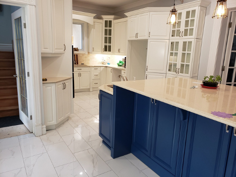 a kitchen with bright white cabinets and a blue island base