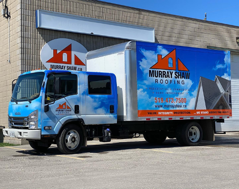 large blue branded work truck sitting in front of a building