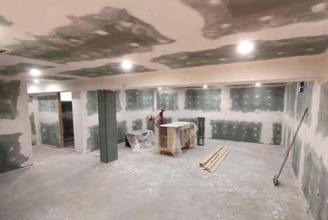 view of basement under renovation with putty on the walls and various tools and resources laying around