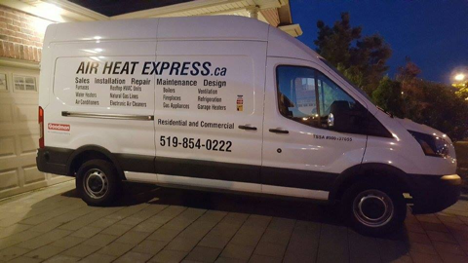 a white work truck with company branding on the side at night