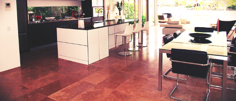 red and brown floor tiles in a kitchen and dining room with white and black furniture on top