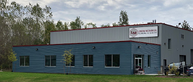 exterior of a large industrial building with blue and grey detailing on an overcast day
