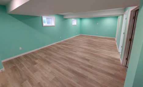 wood vinyl floor panels in a basement with sea foam green paint on the walls