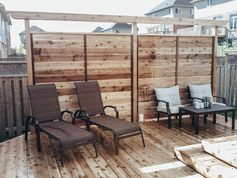 deck with large wooden wall blocking neighbours view with patio furniture sitting against wall