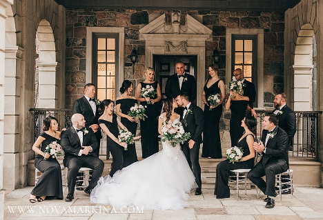bride and groom kissing surrounded by their bridal party