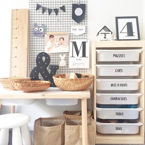 organized space with shelves to the right baskets on a table to the left and a grid board on the wall