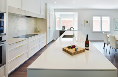 long kitchen island with white countertop and snacks and wine on top
