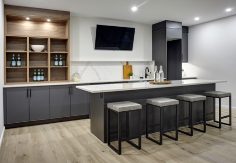 kitchen island with bar stools with dark cupboards and white countertop