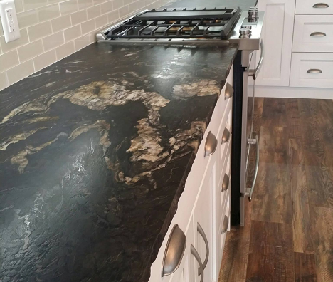 patterned dark countertop with brown detailing by the stove