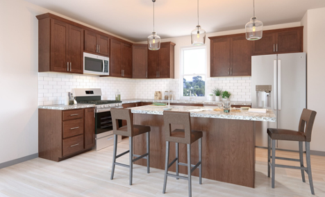 white and brown kitchen with dining chairs around kitchen island with overhead lights above
