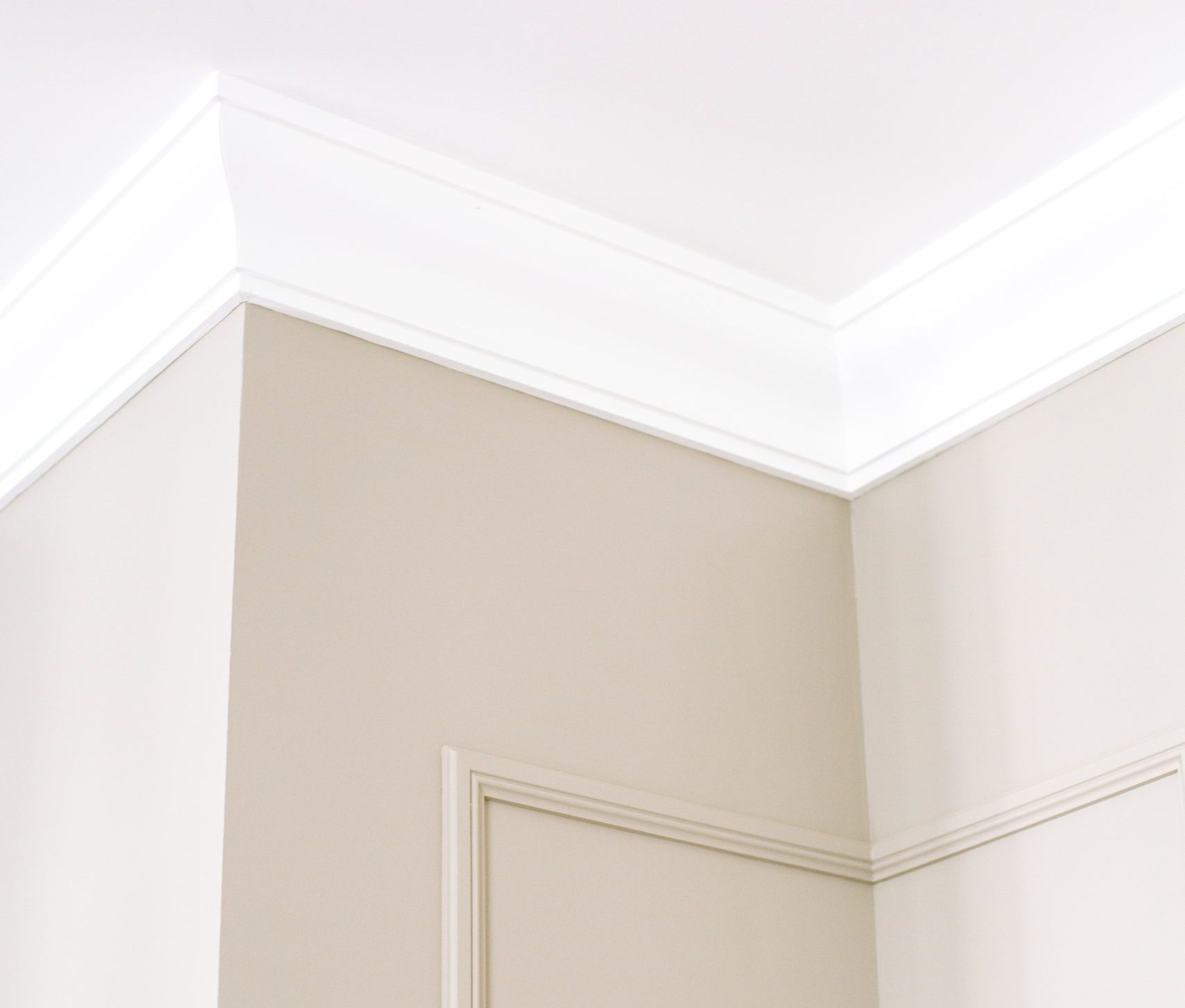 Crown moulding on the corner of a wall and wall moulding below