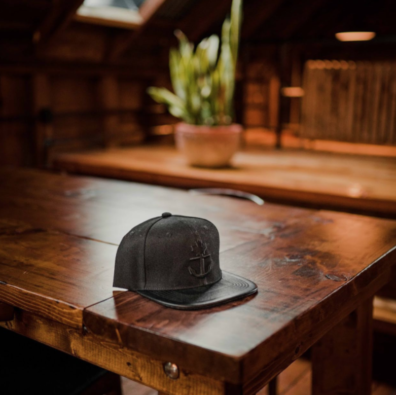 Black hat sitting on dark wooden table