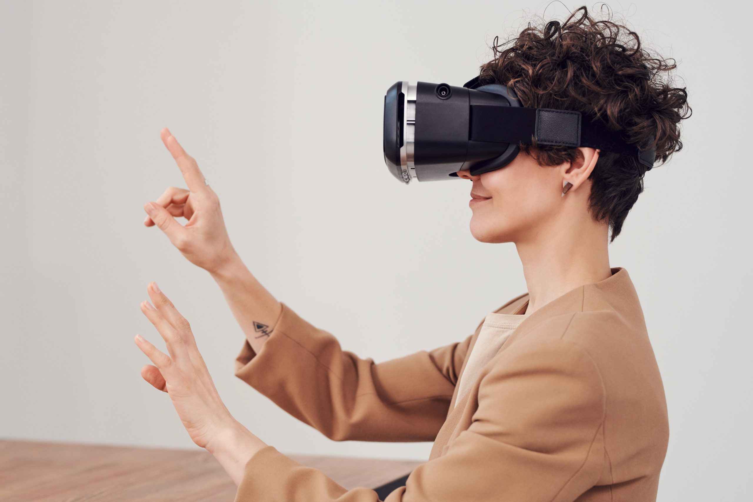 Woman with her arms raised wearing a virtual reality headset