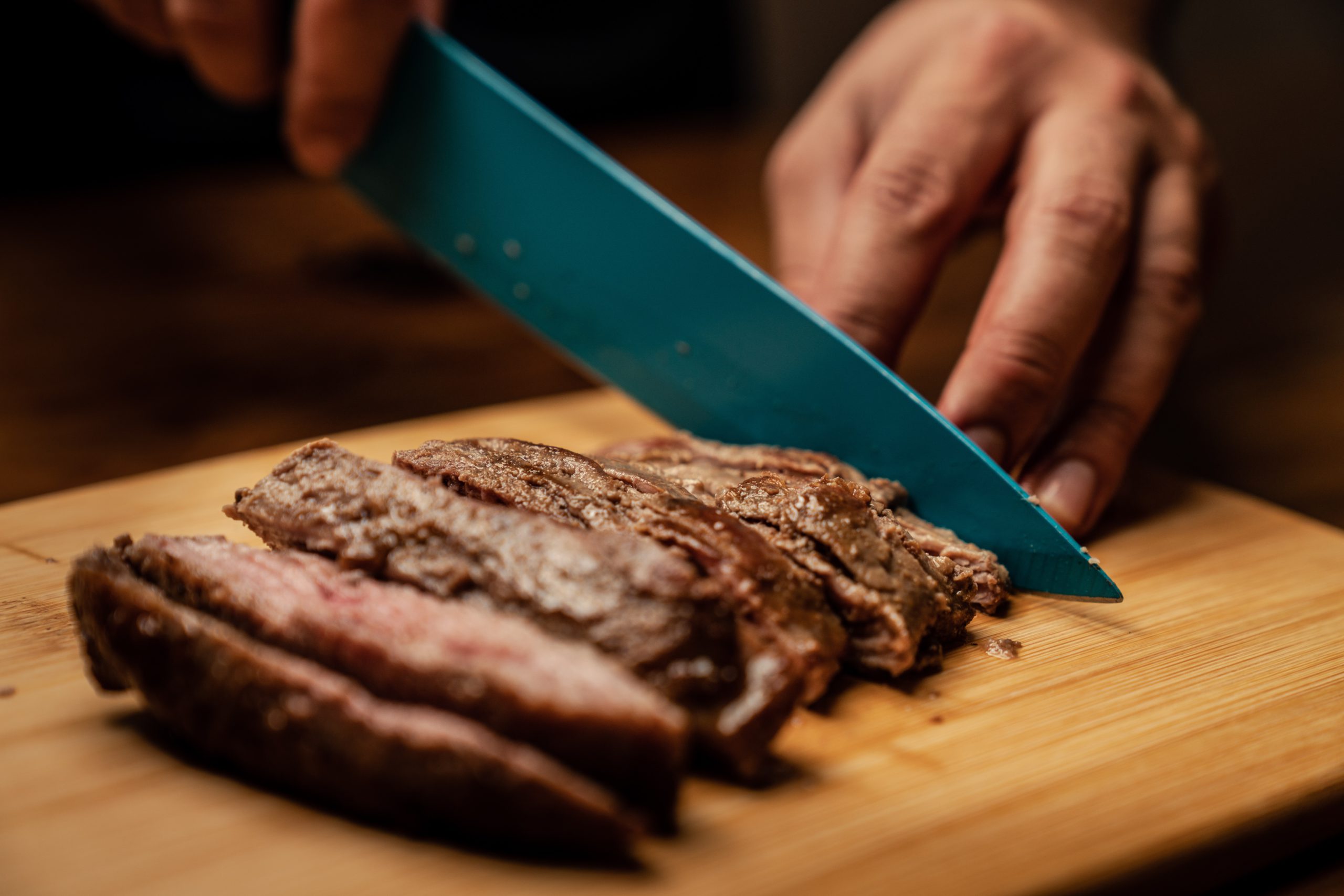 Piece of steak being cut on a cutting board