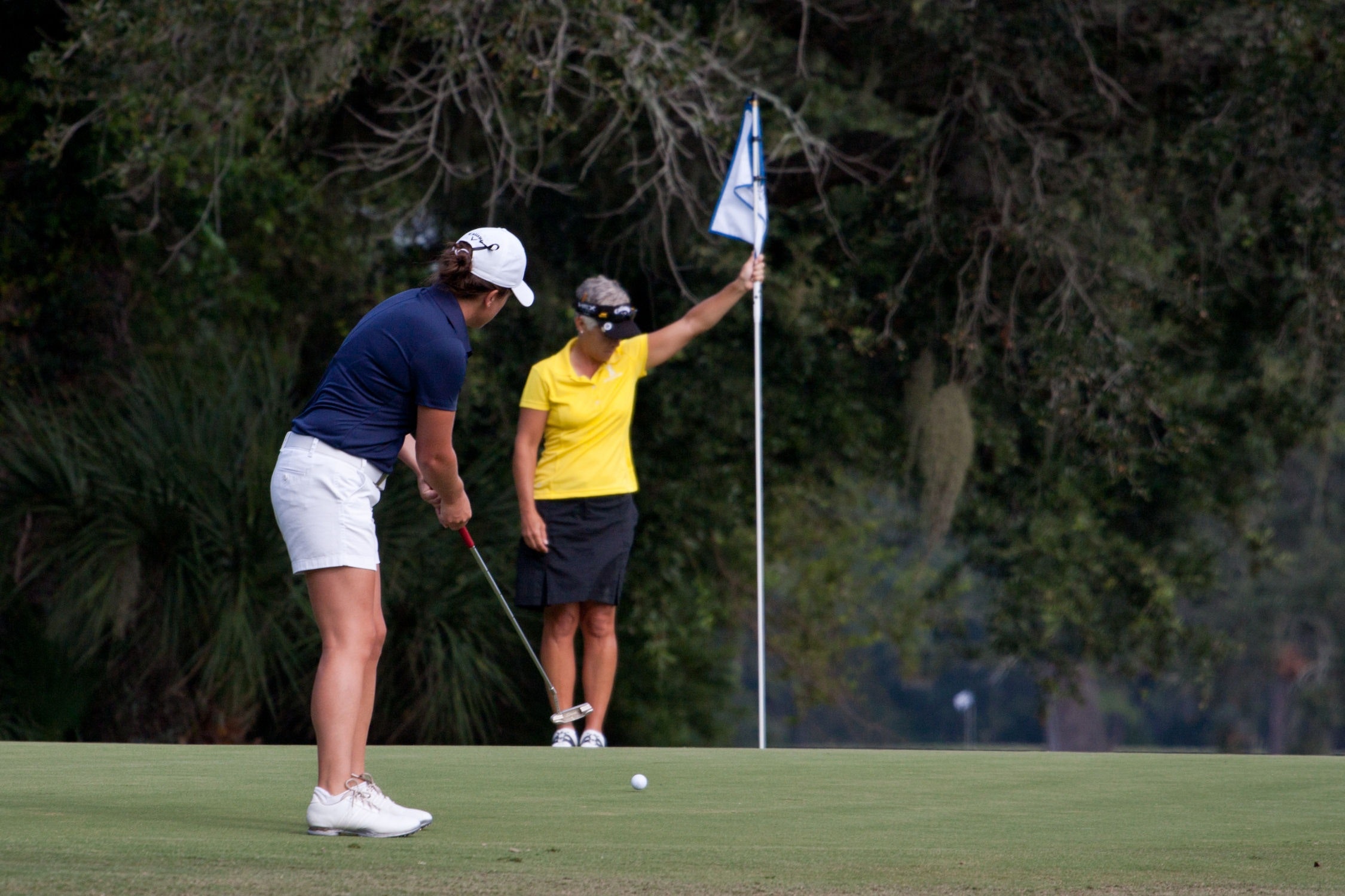 Woman putting and another woman holding up the pin