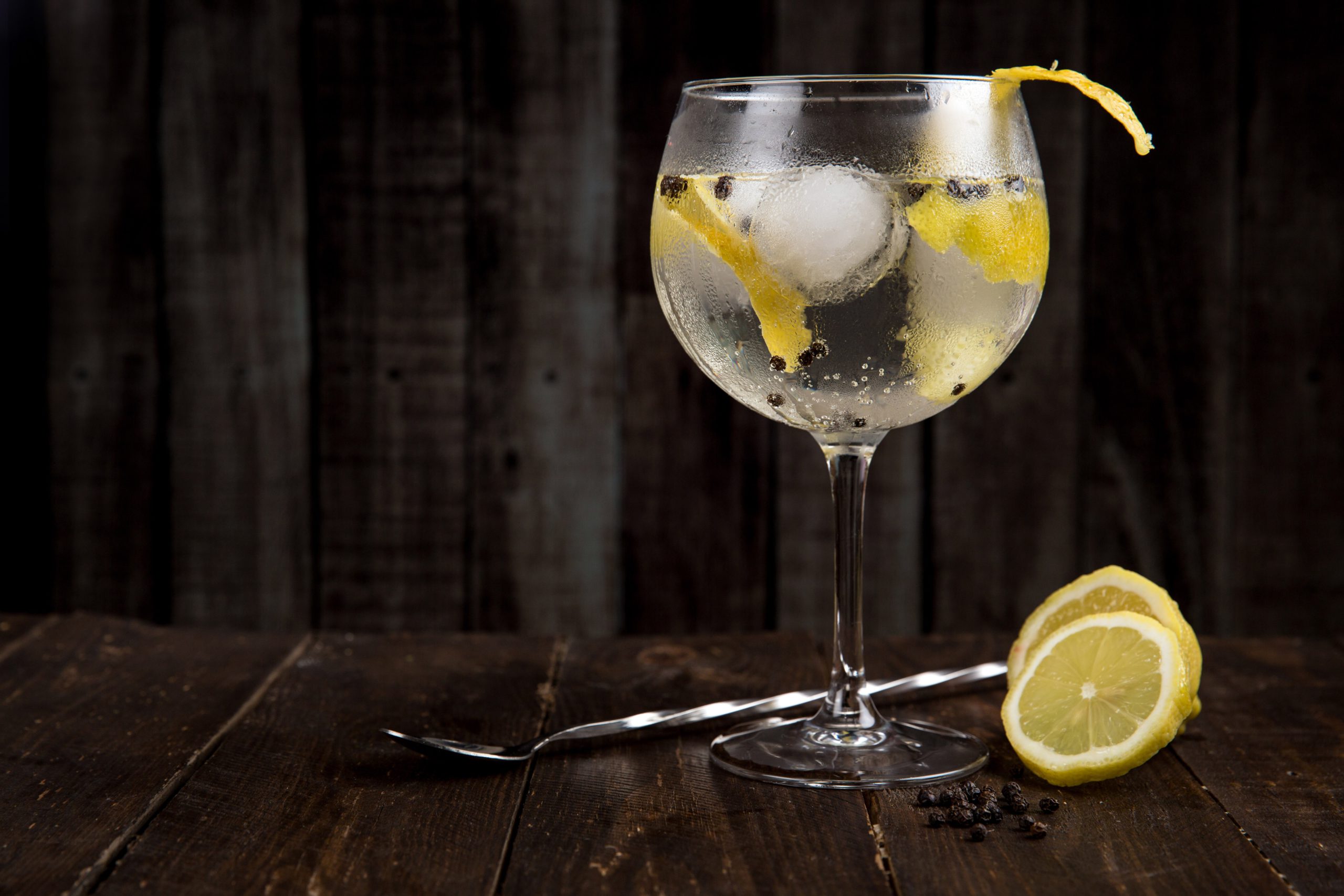 Elegant cocktail with lemon on a dark wood surface