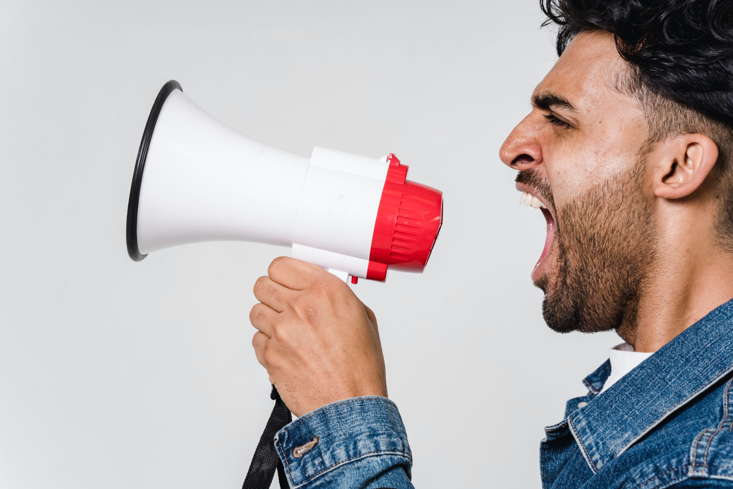 man yelling into a megaphone against a white background