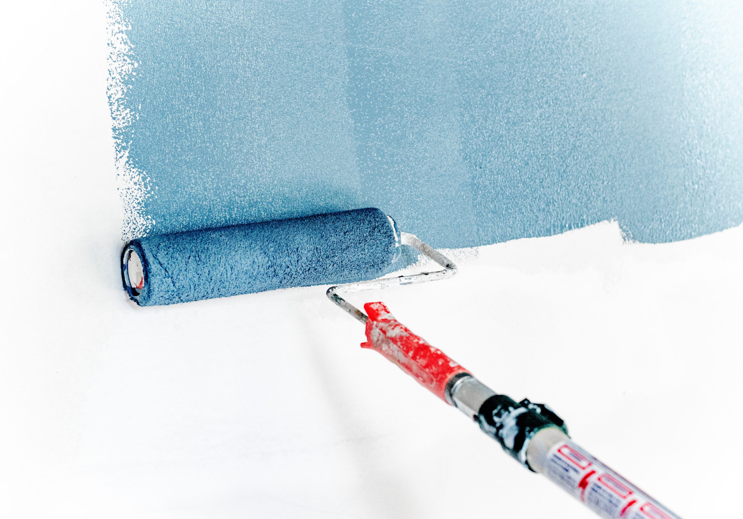 paint roller with blue painting a white wall