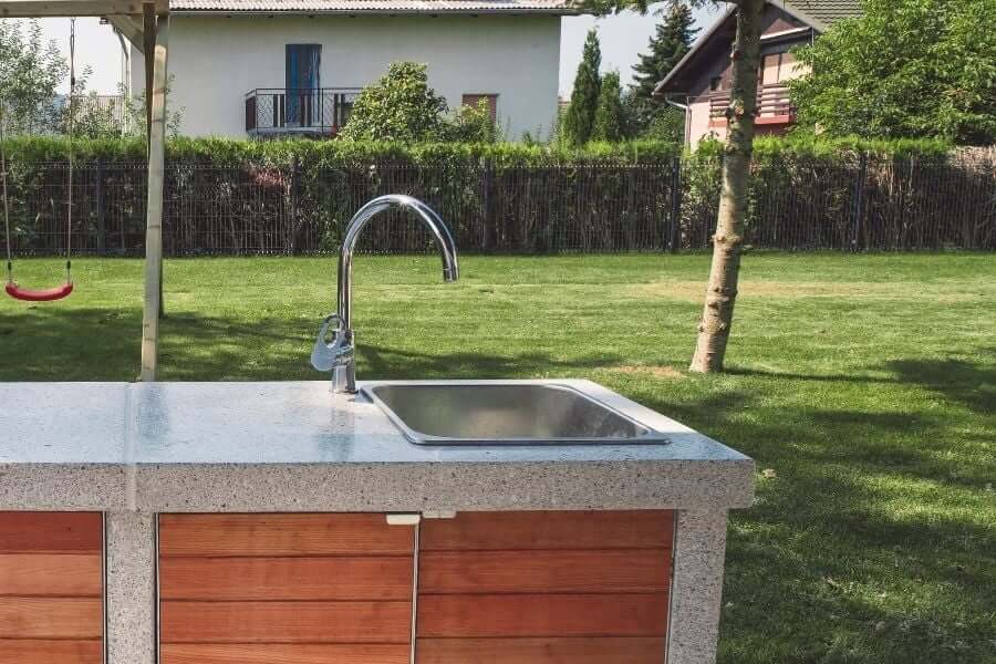 Outdoor sink with counter space with swing in the background