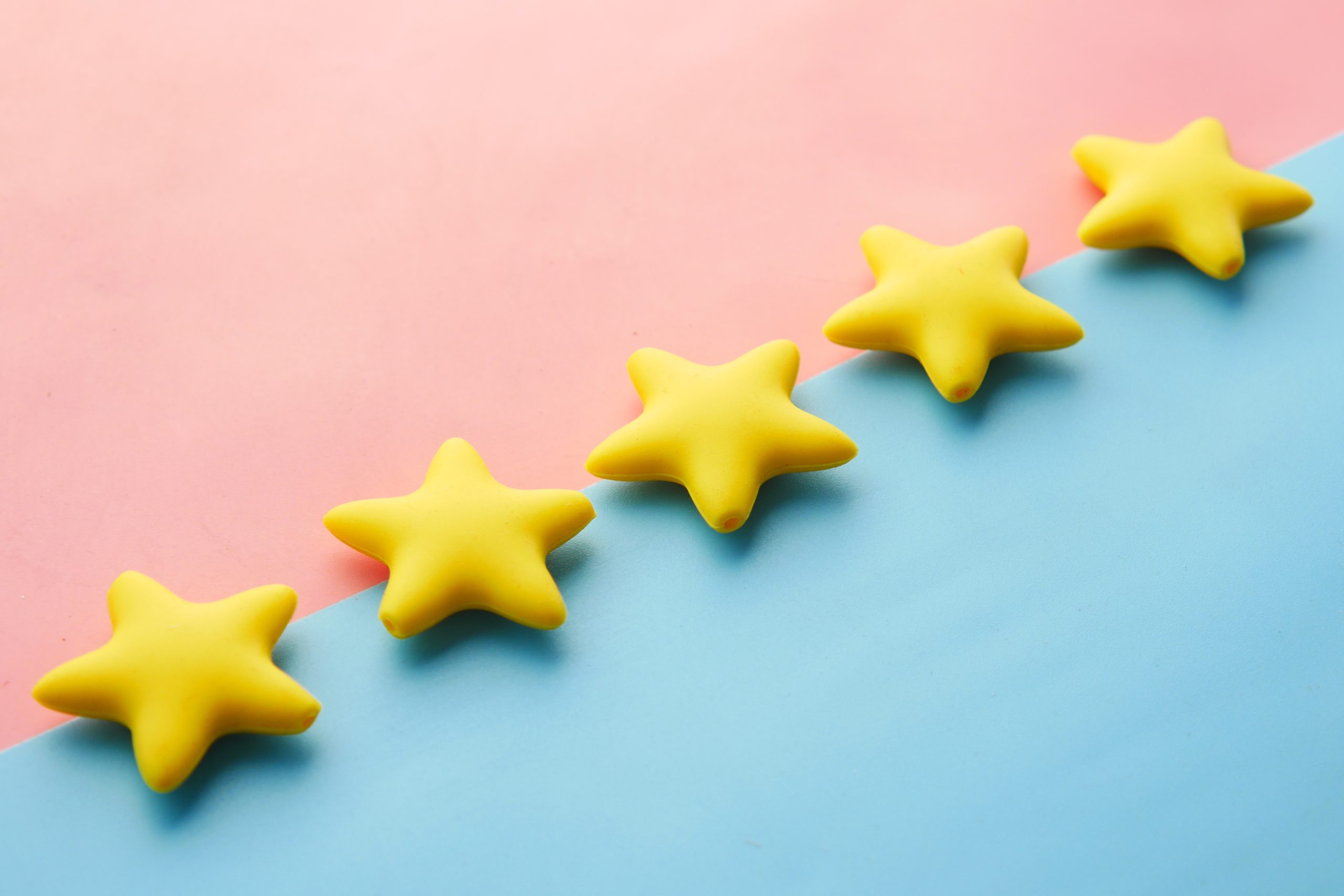Five stars lined up on a blue and pink background